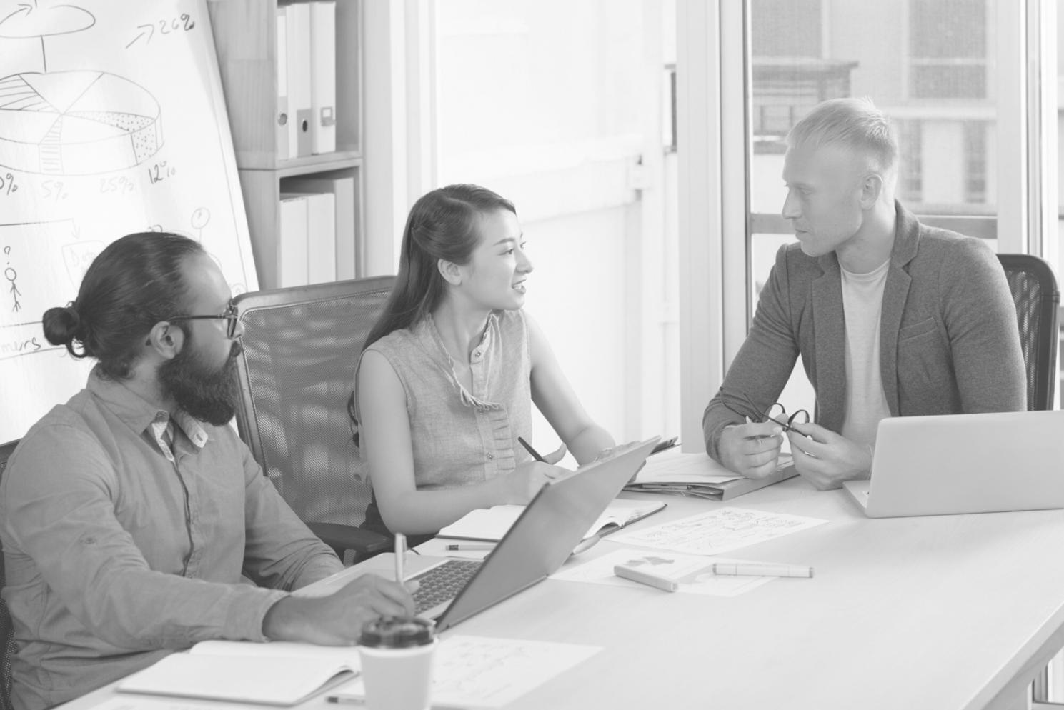 Finance team reviewing budget approval workflow on computer screens during training session